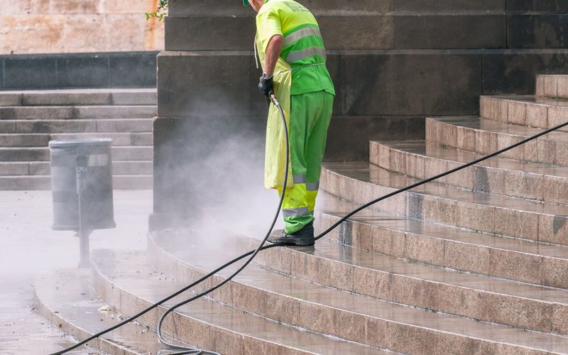 Half-cleaned driveway showing the waterblasting line